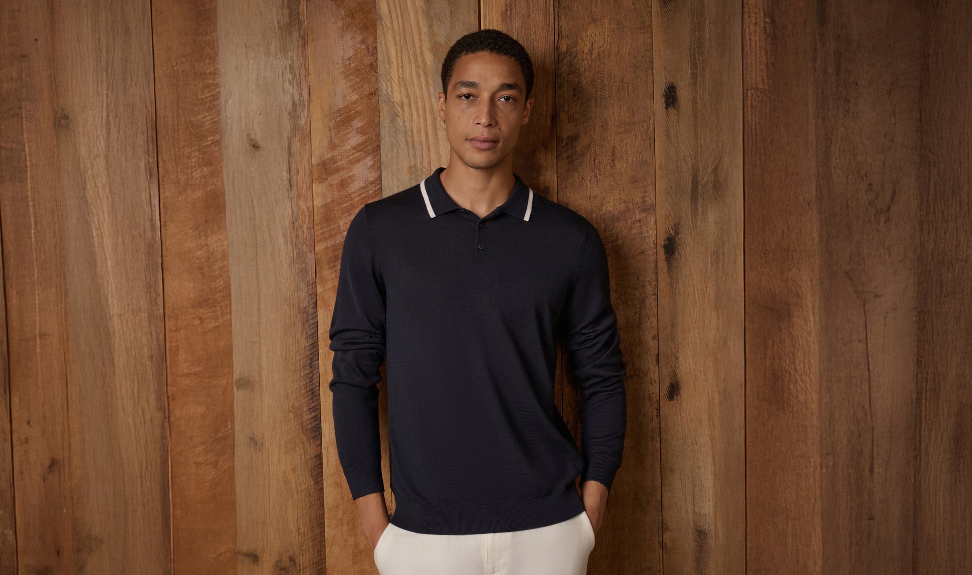Man wearing a dark blue long-sleeve shirt against a wooden background