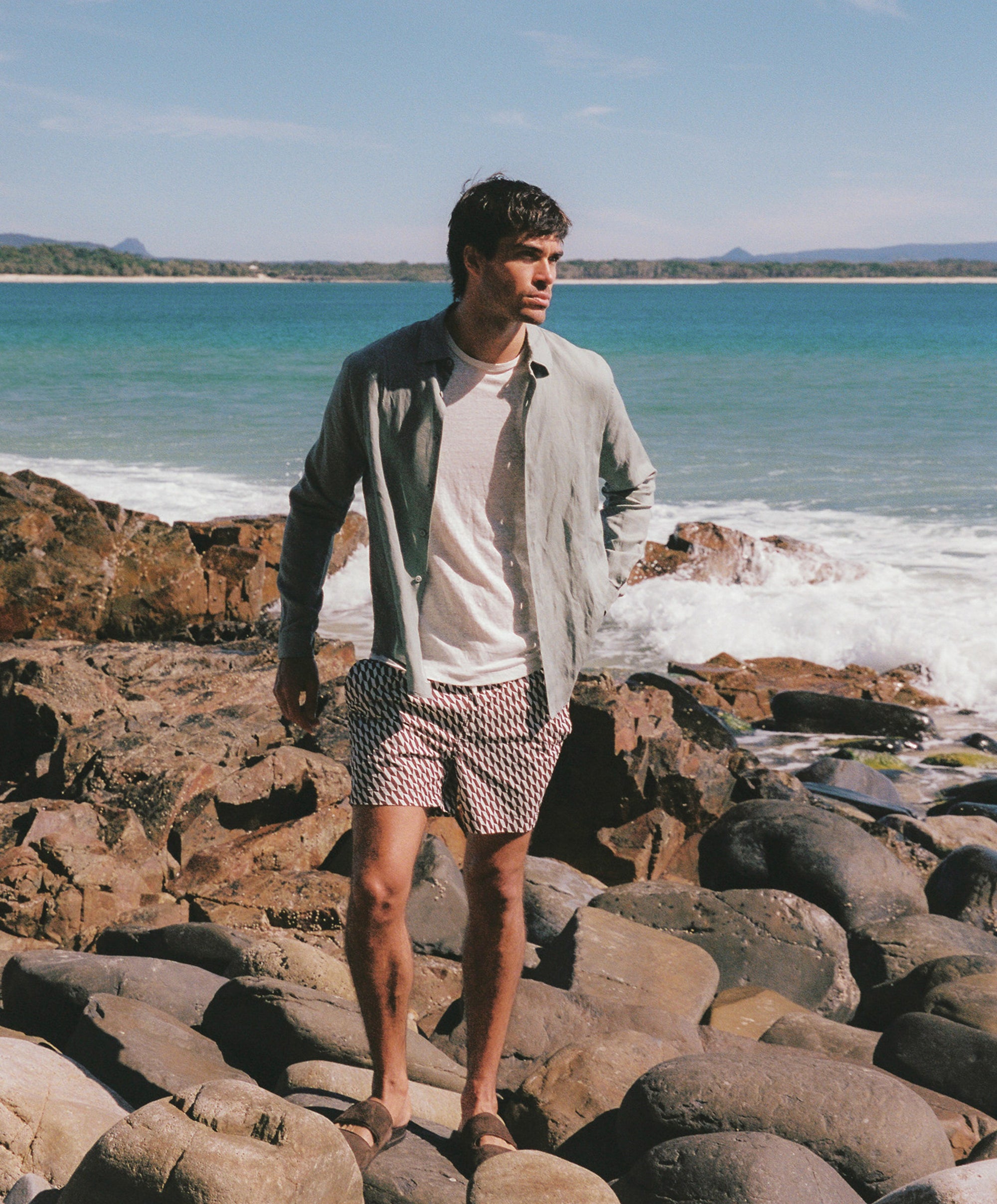 Man standing on rocks by the ocean onia