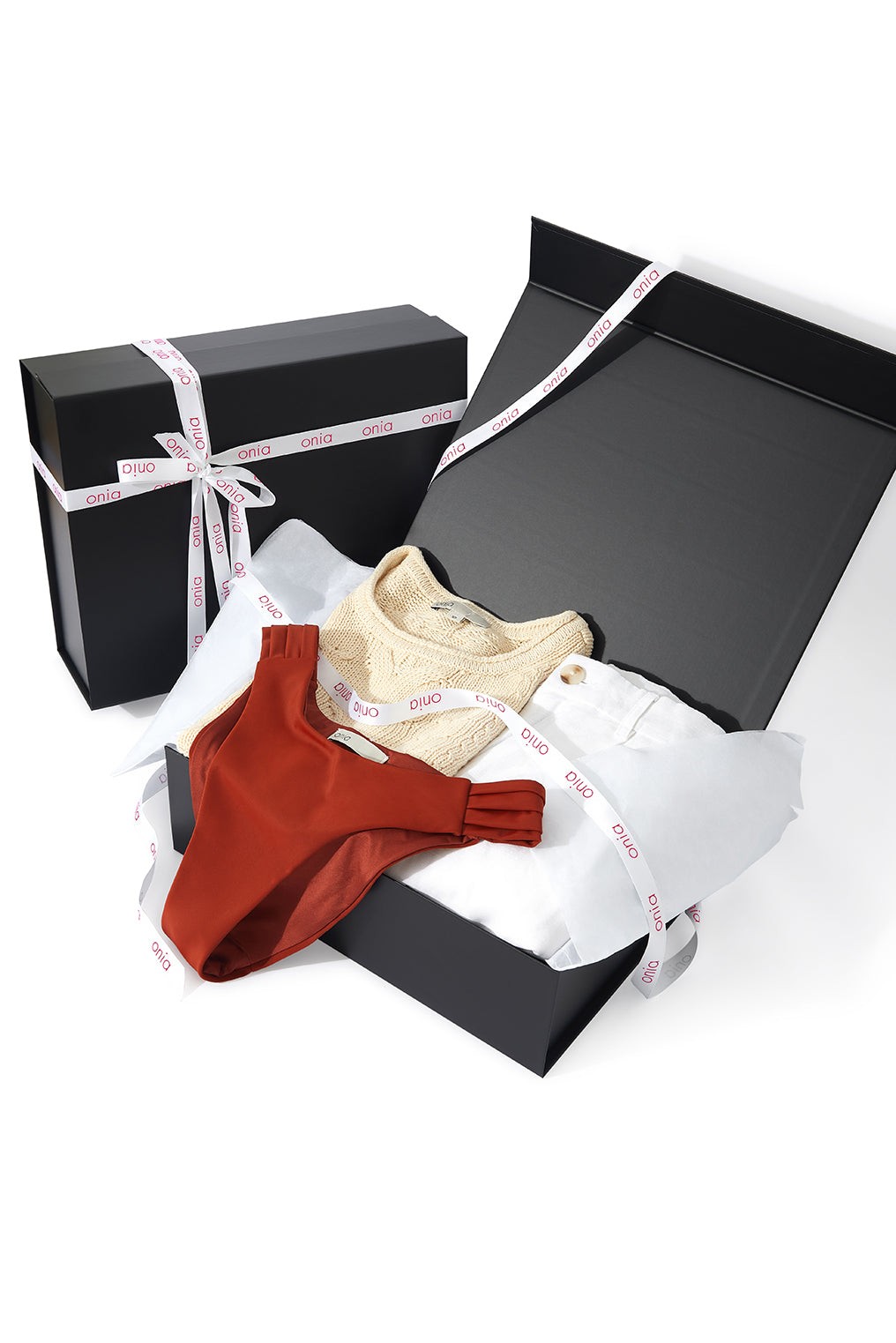 Black gift box with a red and beige item on a white background