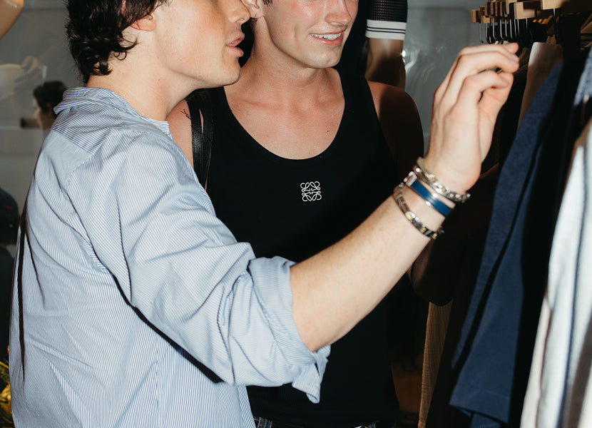 Two people looking at clothes on a rack in the Onia store